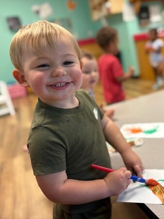 Smarr boy smiling while painting